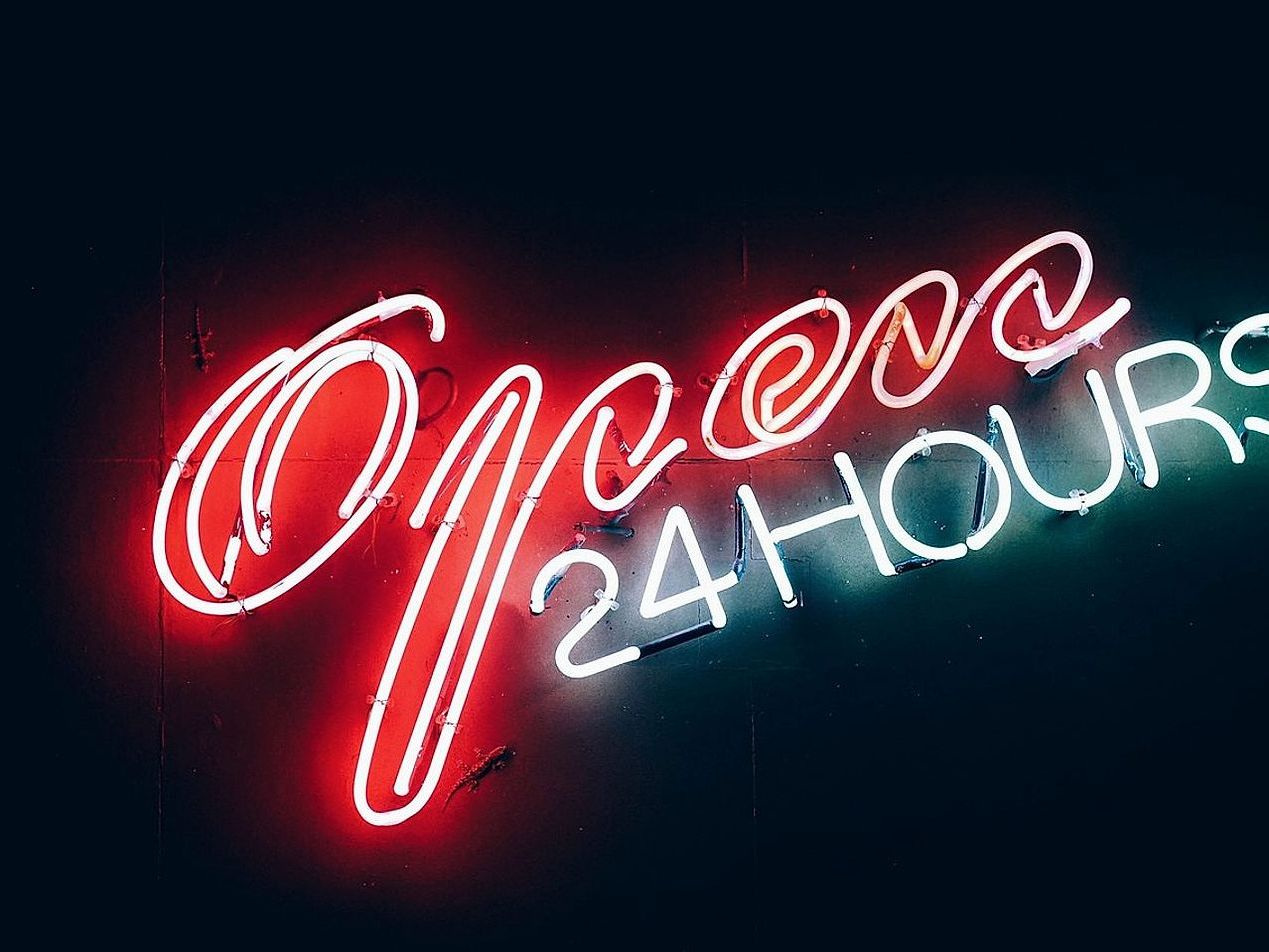 Retro posterler ve şık neon aydınlatması ile dolu yaratıcı çalışma alanı